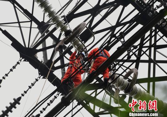 圖為電力工人在70多米高空作業(yè)，為特高壓復(fù)奉線(xiàn)重慶段進(jìn)行八年來(lái)首次大修?！≈芤?攝